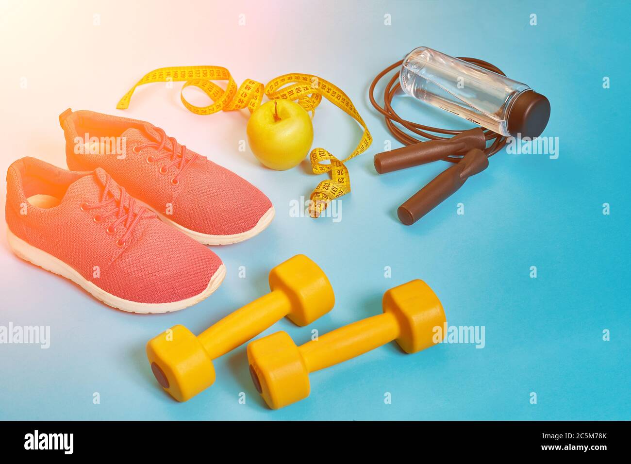 Flat lay of dumbbell, bottle of water, jump rope and sneaker, sport equipments, fitness items