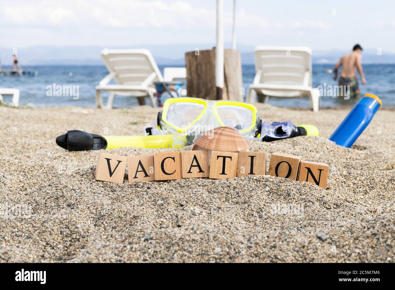 Holiday concept from wooden cubes. Wooden cubes embedded in sand Stock ...