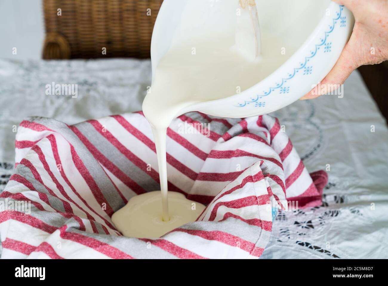 Pouring yoghurt and salt mixture into cloth to make labneh Stock Photo