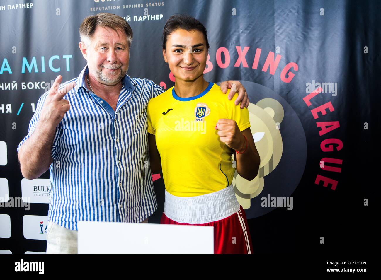 Distinguished Ukrainian boxing coach Vladimir Bogatyrenko with one of gifted Ukraine's Women's Boxing League fighters Valeria Eroshenko after weigh in Stock Photo