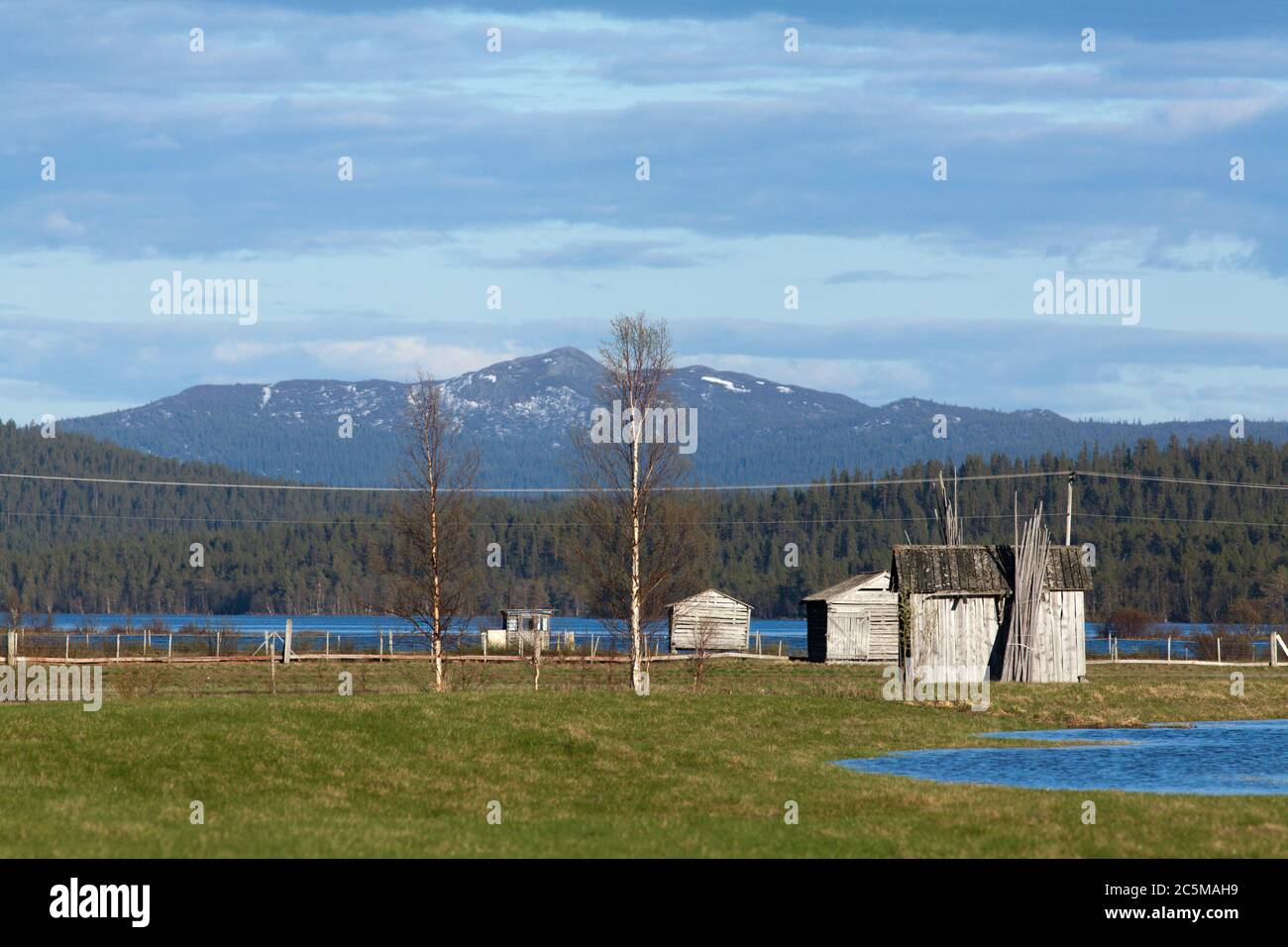 Water from a flooded river cover a delta land. Wooden barns on the