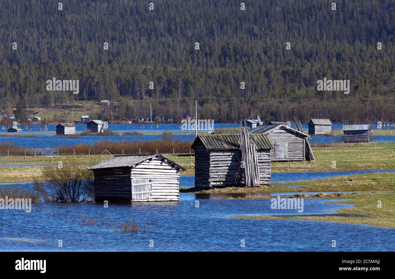 Water from a flooded river cover a delta land. Wooden barns on the