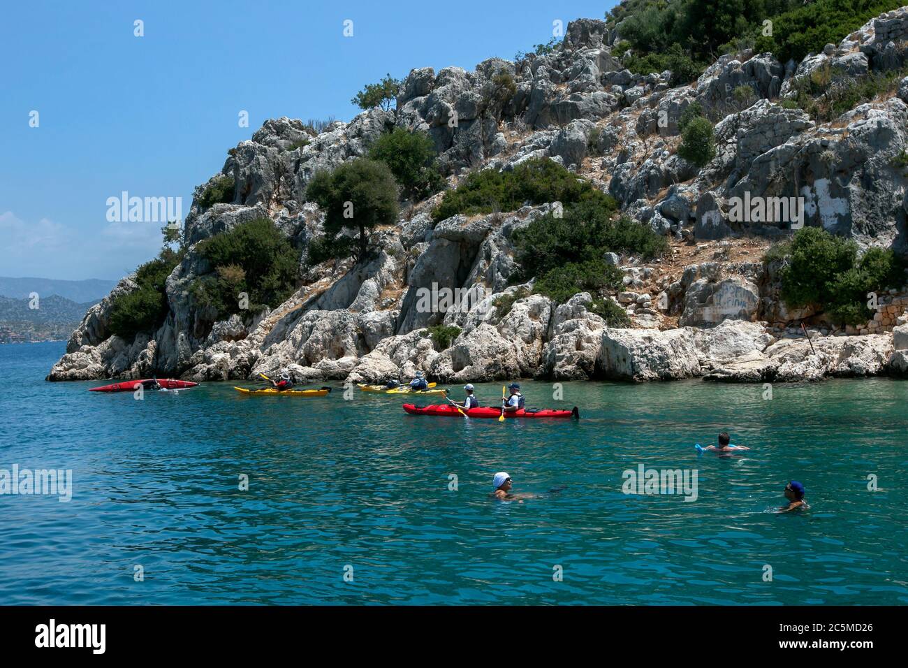 Kayakers paddle adjacent to the Sunken City of Simena off Kekova Island in Turkey. The city sank into the Mediterranean Sea. Stock Photo