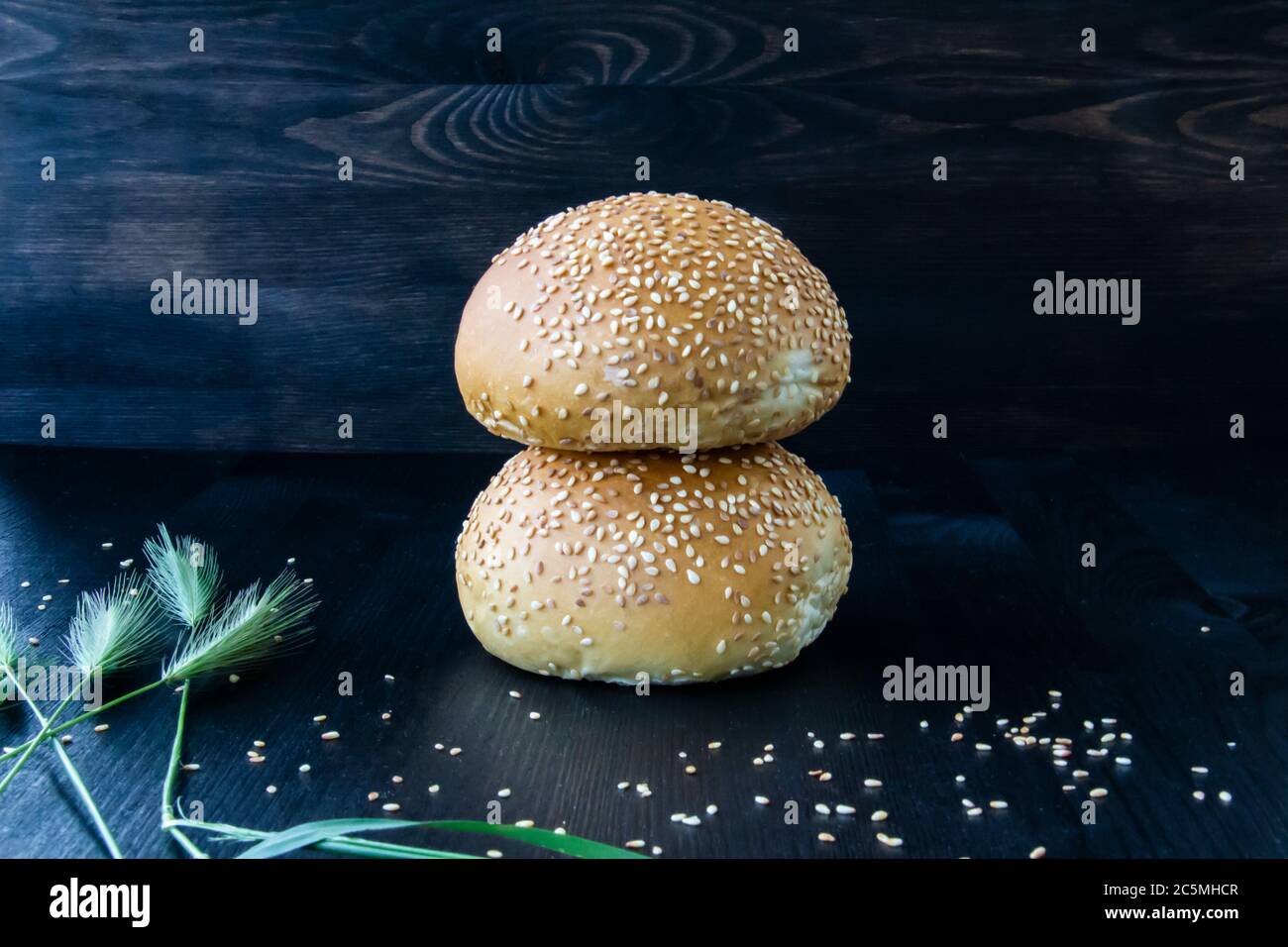 Two buns  with sesame seeds on the wood background. Stock Photo