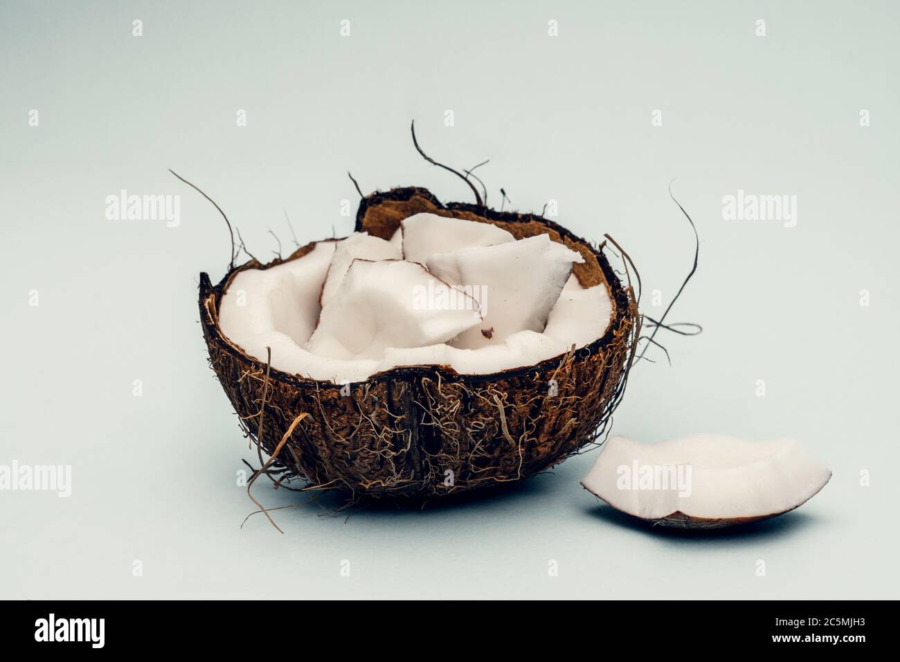 Parts of coconut on a colored background. Close up. Fresh ripe coconut