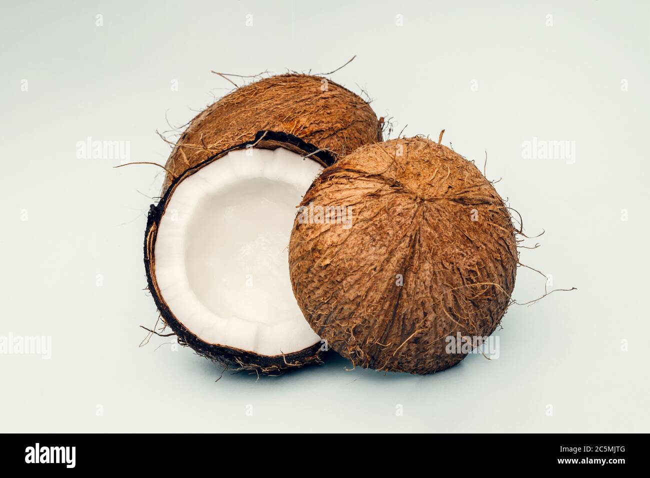 Parts of coconut on a colored background. Close up. Fresh ripe coconut