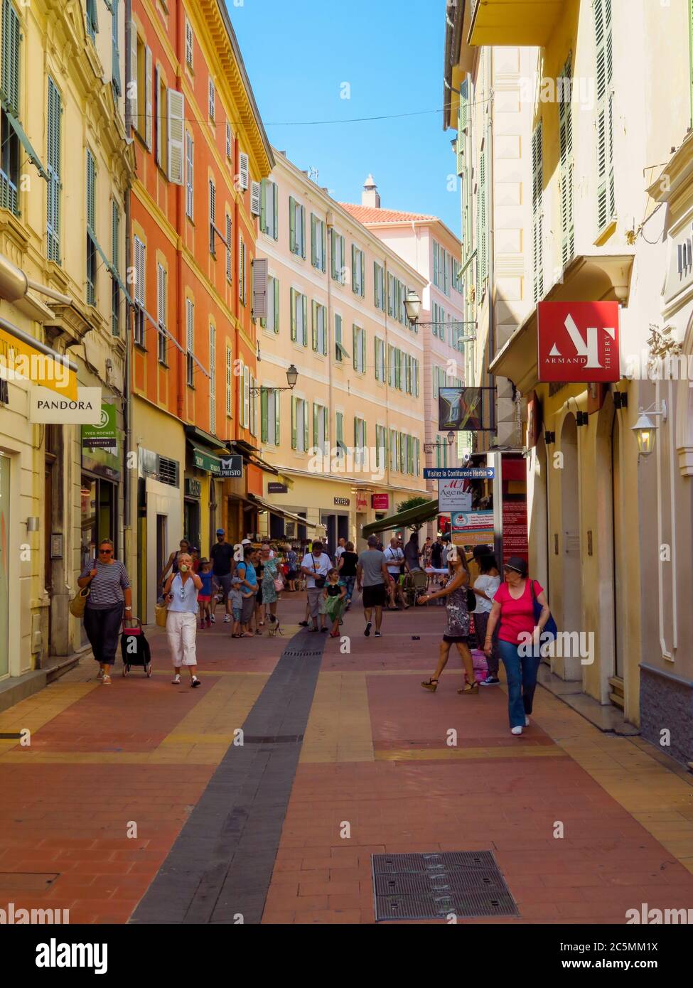 Menton, France - June 30, 2018: Small street in the old town of city. Menton is a seaside town on the French Riviera. Unidentified people walk down th Stock Photo