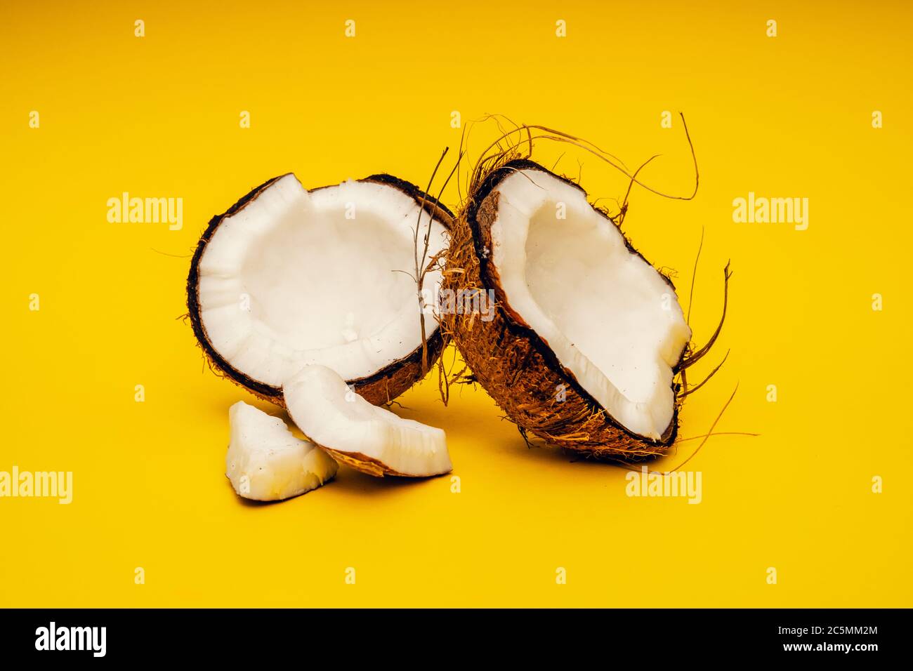 Parts of coconut on a colored background. Close up. Fresh ripe coconut