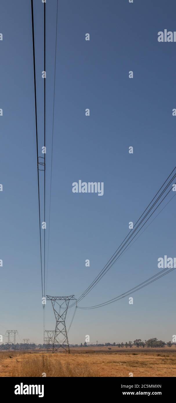 Overhead power lines and steel electric pylons isolated in a winter ...