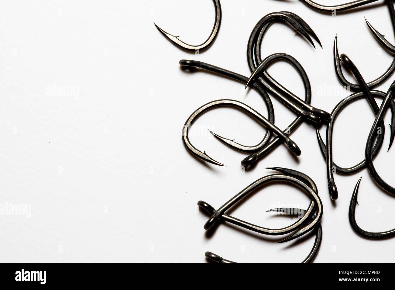 Large barbed fishing hooks on a white background with copy space Stock Photo