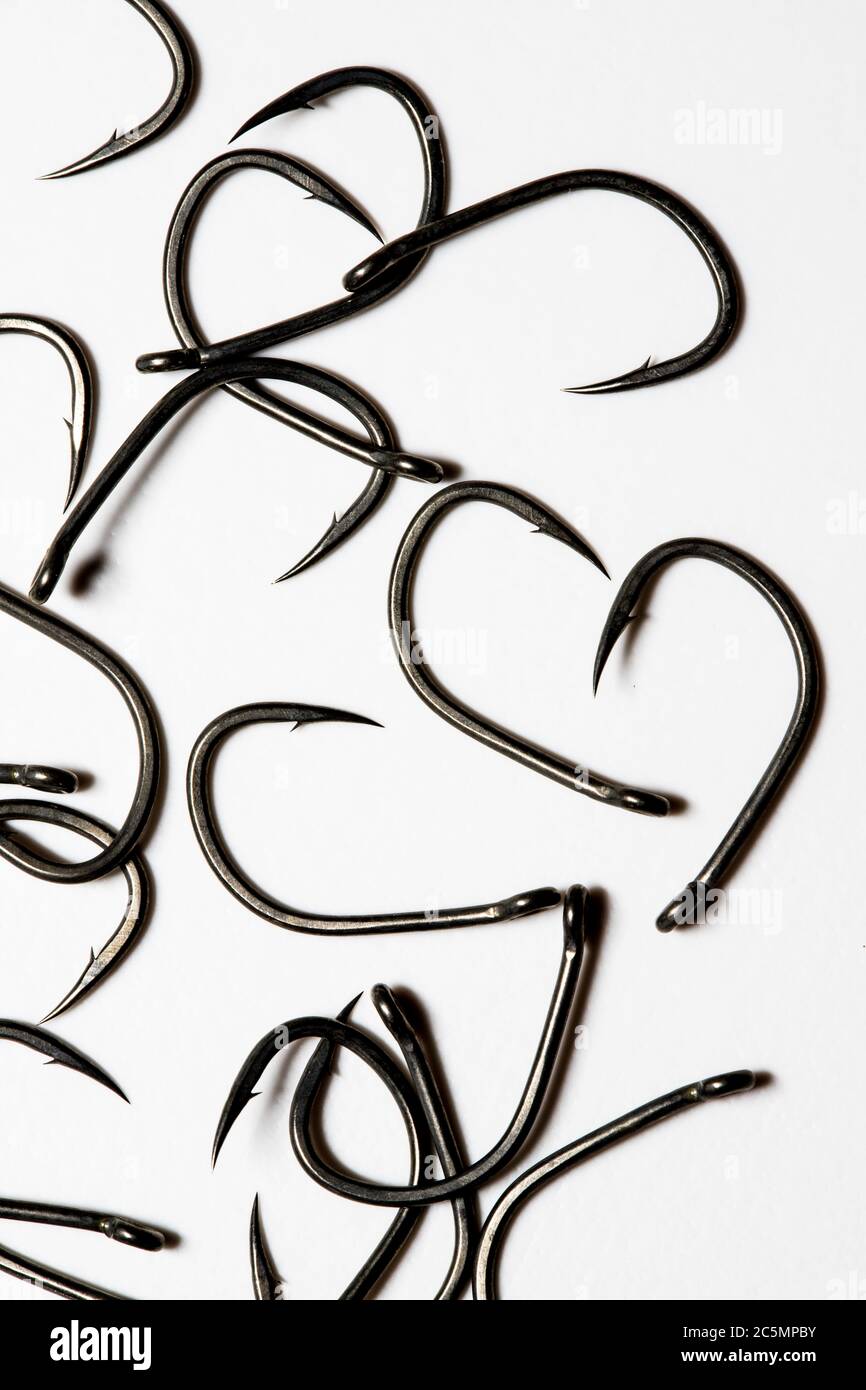 Barbed fishing hooks with sharp points on a bright white background Stock Photo