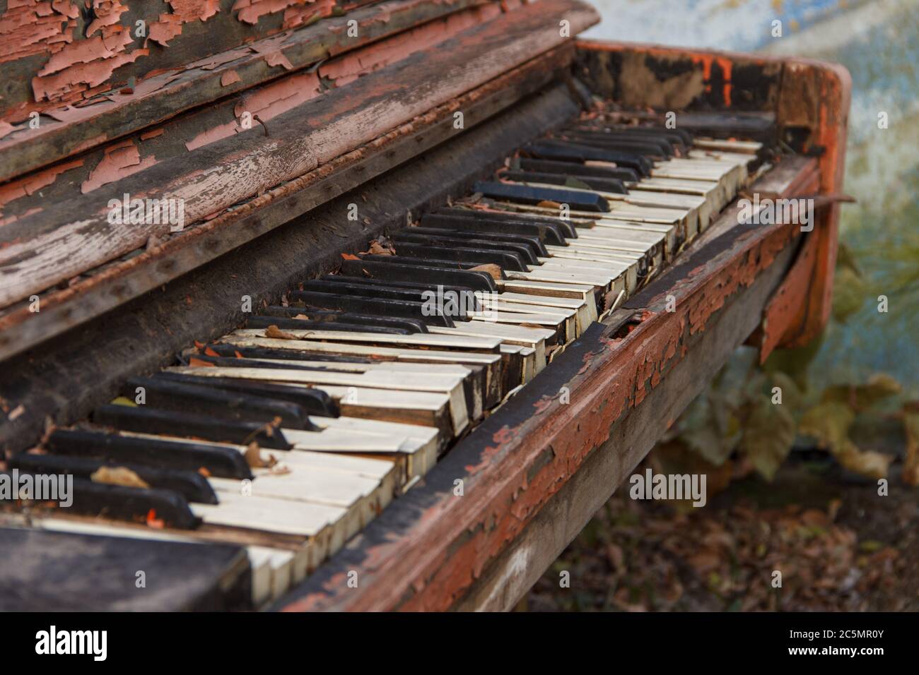 An old broken piano in the street with a large pan with white and black