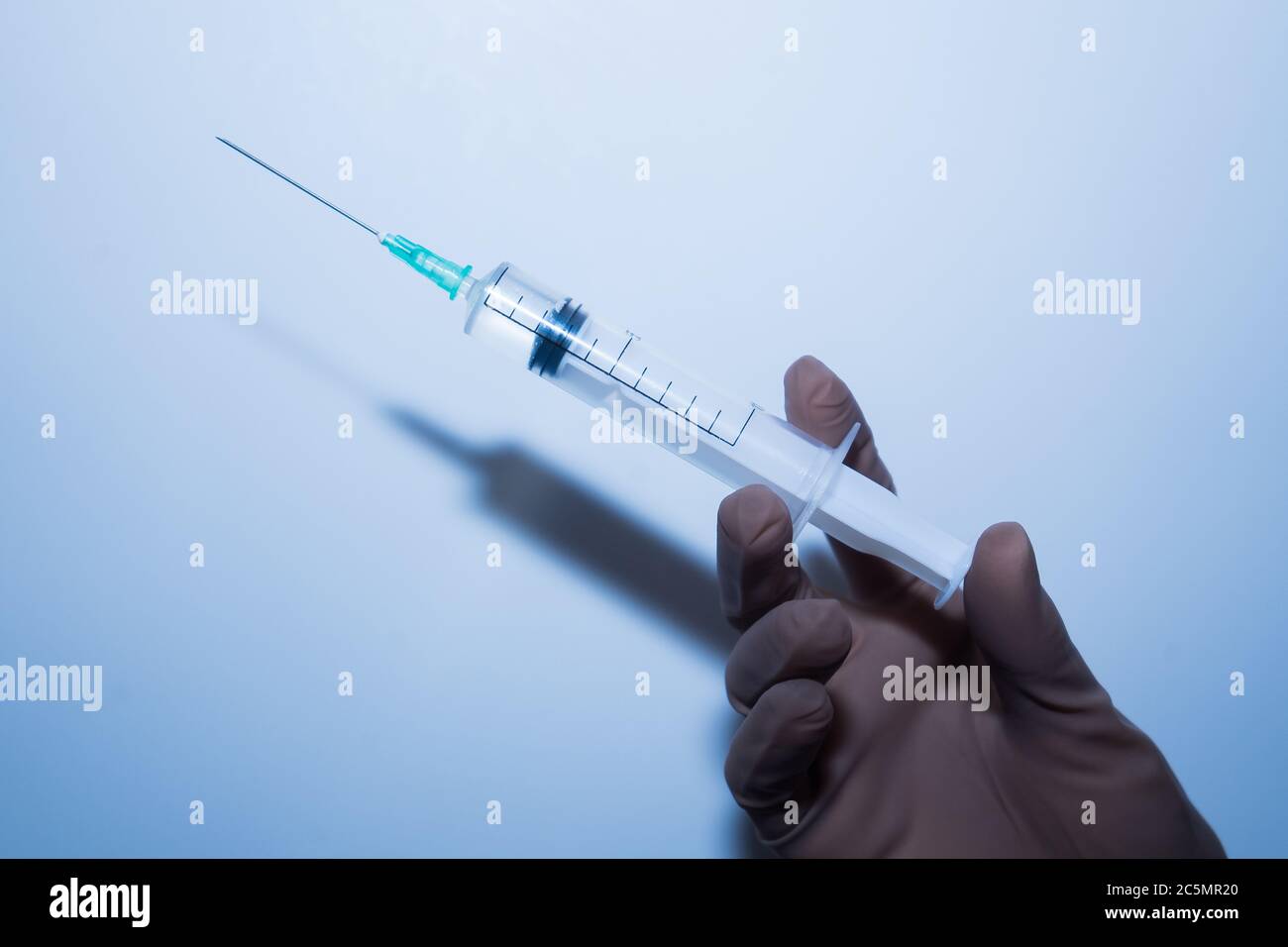 Syringe in the doctor hand in a medical rubber glove. The doctor is vaccinated.  Stock Photo