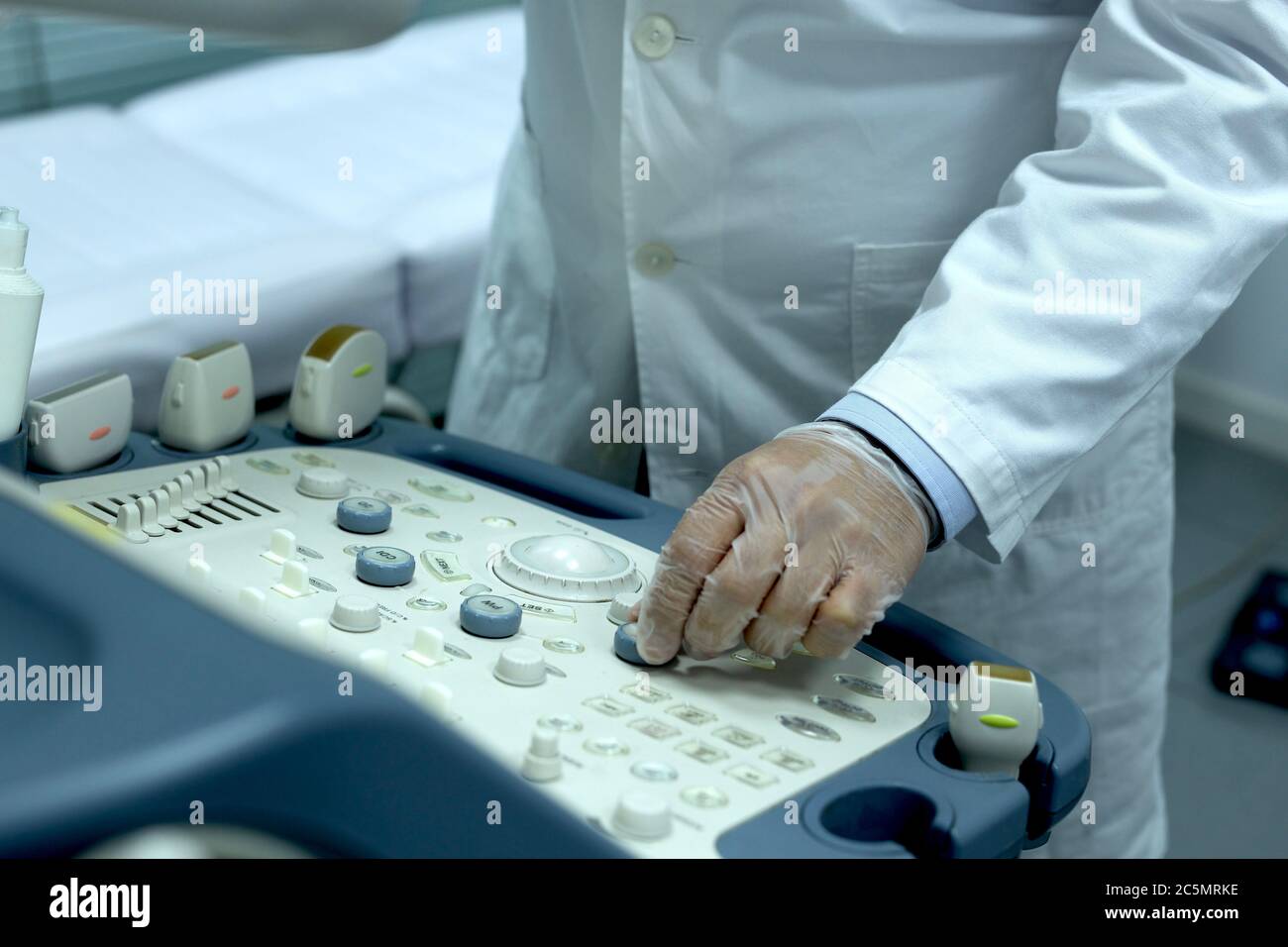 Close-up of a doctor using a machine to perform an ultrasound on a ...