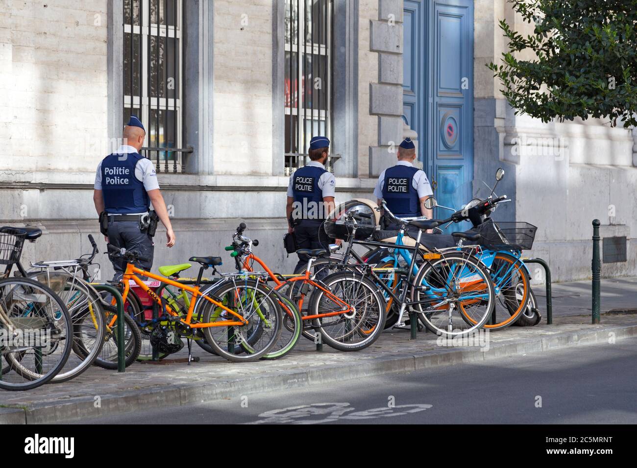Brussels, Belgium - July 03 2019: Three policemen wearing bulletproof vest patrolling the street. Stock Photo