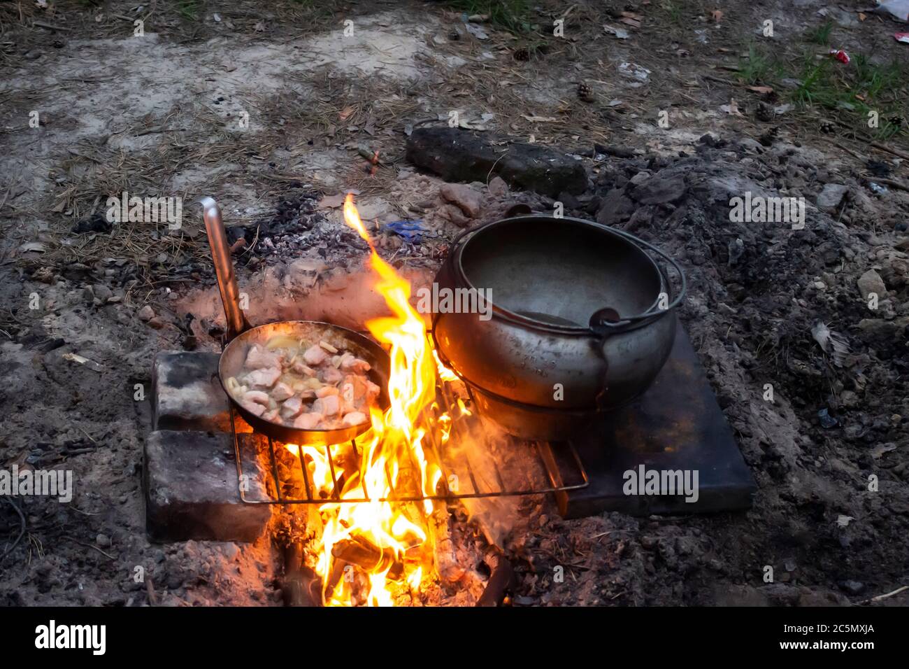 Field kitchen in the forest. Water boils and cooking food. Boiling pot