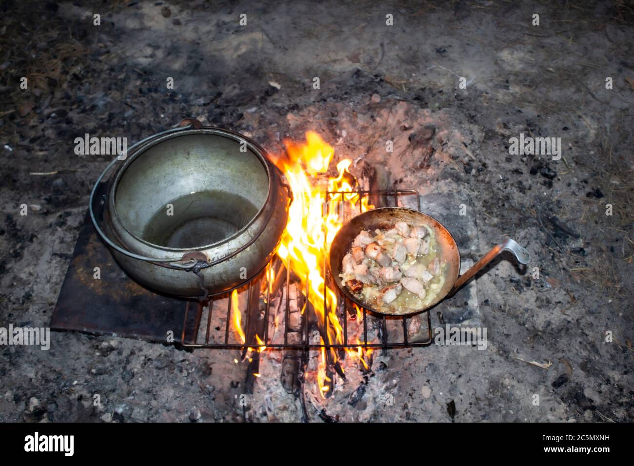 Field kitchen in the forest. Water boils and cooking food. Boiling pot