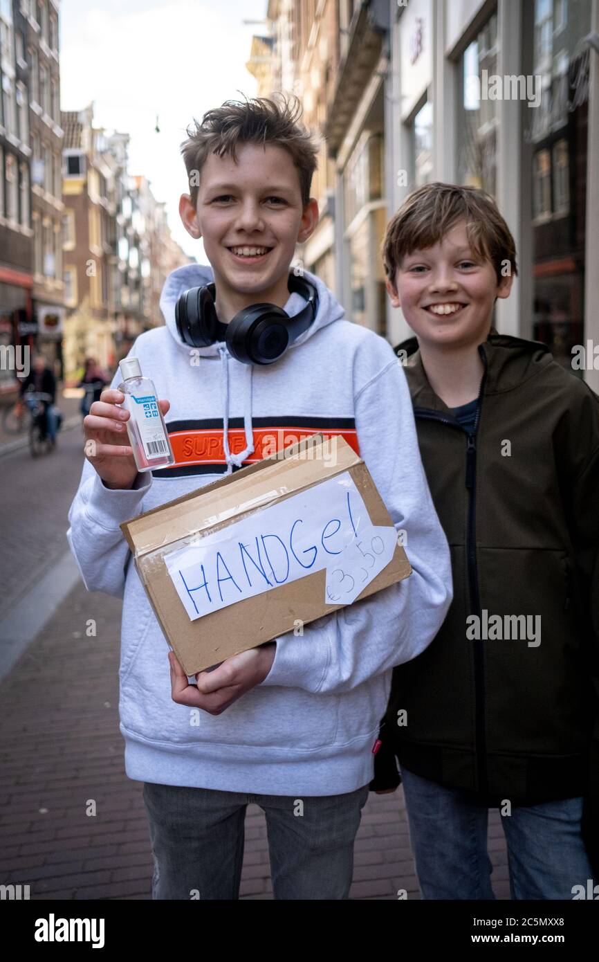 Children selling hydro-alcoholic gel on the street because of the spread of COVID-19. Amsterdam on 28/03/2020 Enfants vendant du gel hydroalcoolique d Stock Photo