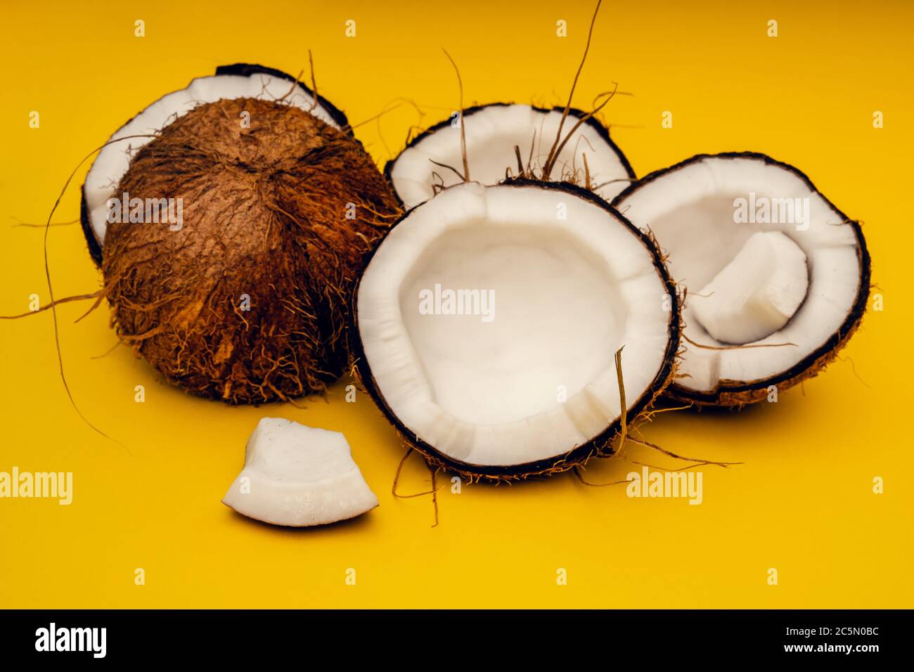 Parts of coconut on a colored background. Close up. Fresh ripe coconut