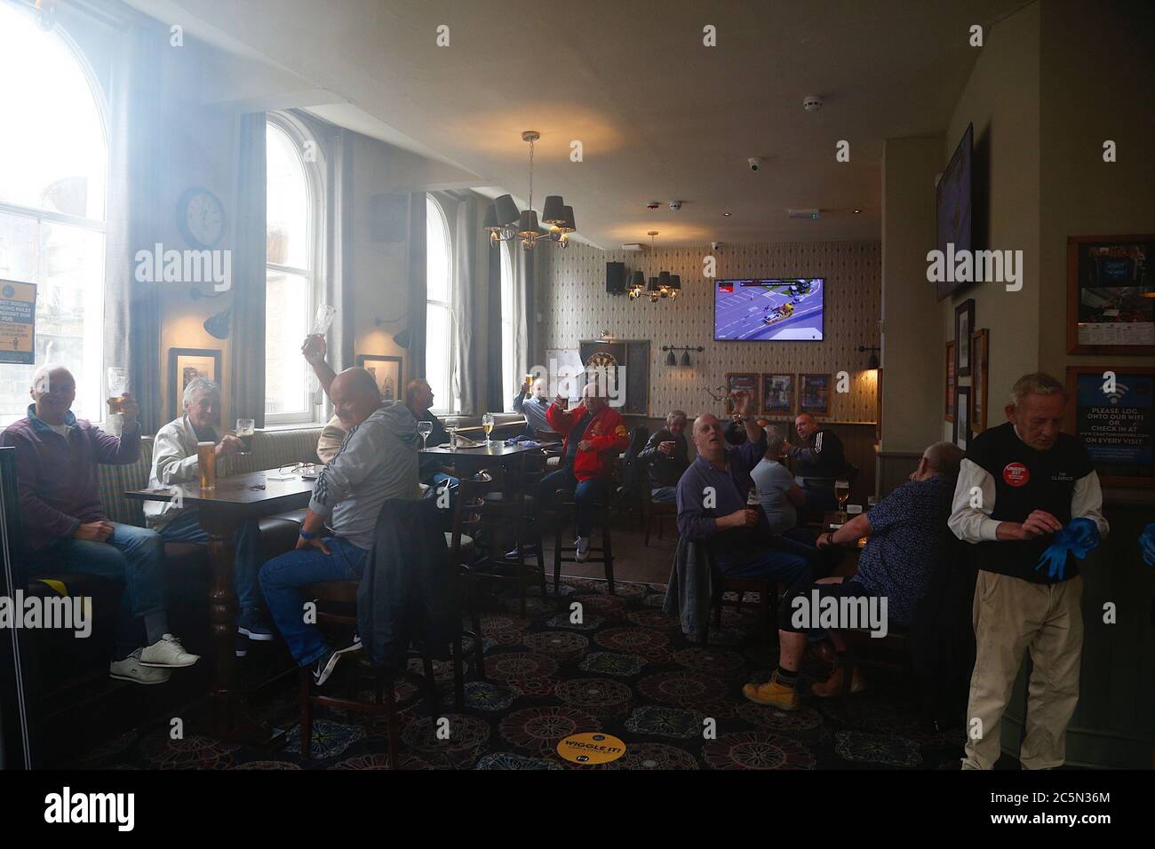 Hastings, East Sussex, UK. 04 Jul, 2020. Coronavirus update: With the government relaxing the rules further, bars, pubs, restaurants and barbershops are allowed to open. The busy Clarence pub in Hastings as. Patrons cheer the opening of pubs in England. Photo Credit: Paul Lawrenson-PAL Media/Alamy Live News Stock Photo