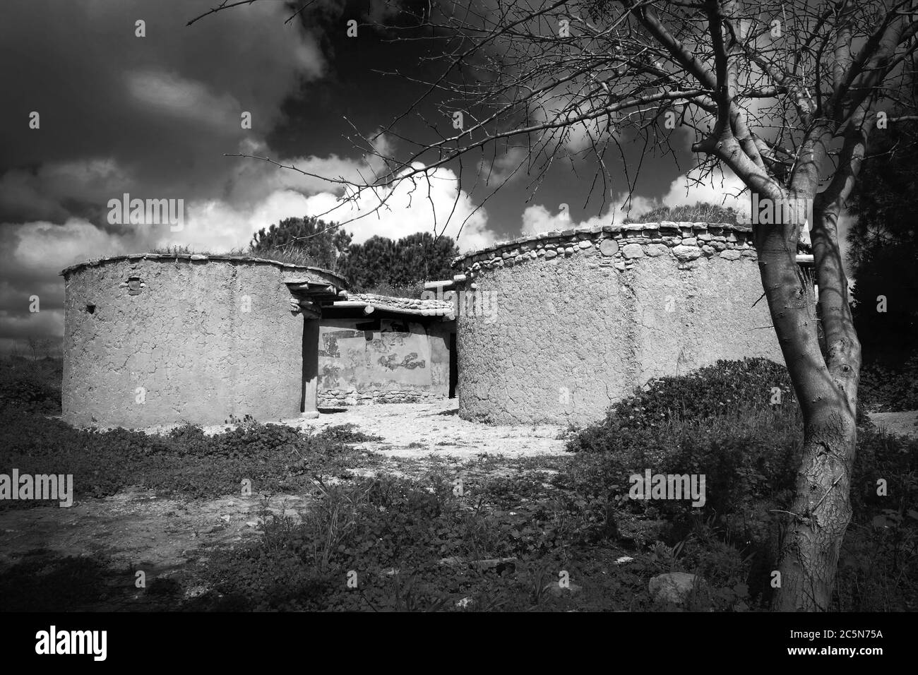 Reconstruction of houses of the Chalcolithic Period (Bronze Age) 3500BC  travel destinations at Lempa Experimental Village in Cyprus black and white m Stock Photo