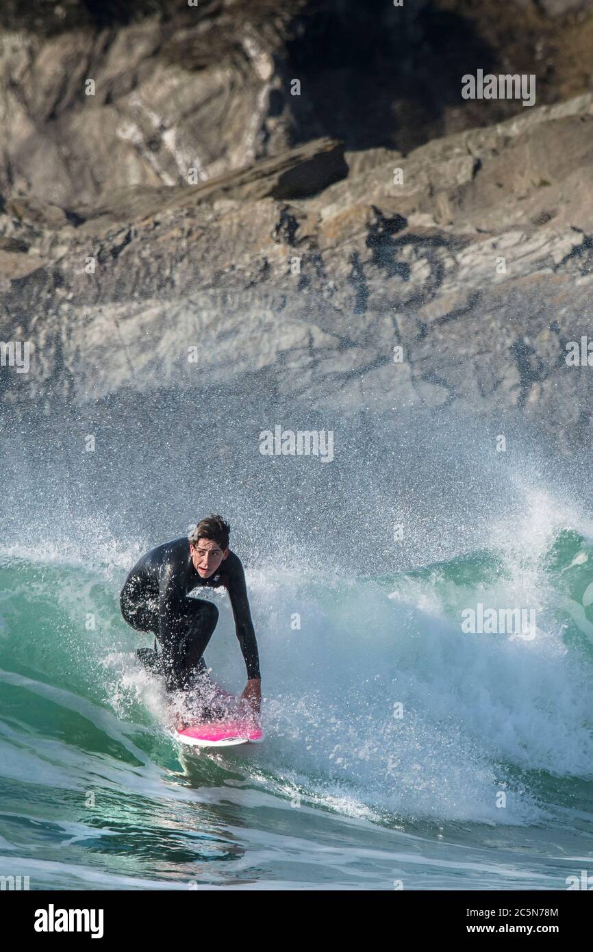 A young male surfer riding a wave at Fistral in Newquay in Cornwall. Stock Photo