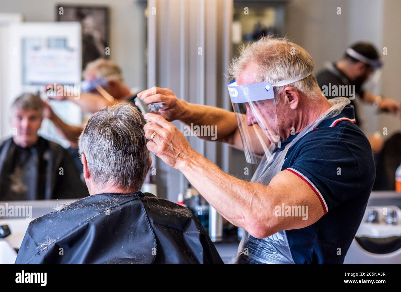 Harrogate, North Yorkshire, UK. 4th July, 2020. David Steca, owner of Steca N.6 barber shop, at work wearing full PPE as barbers reopen to the public on Super Saturday. Credit: ernesto rogata/Alamy Live News Stock Photo