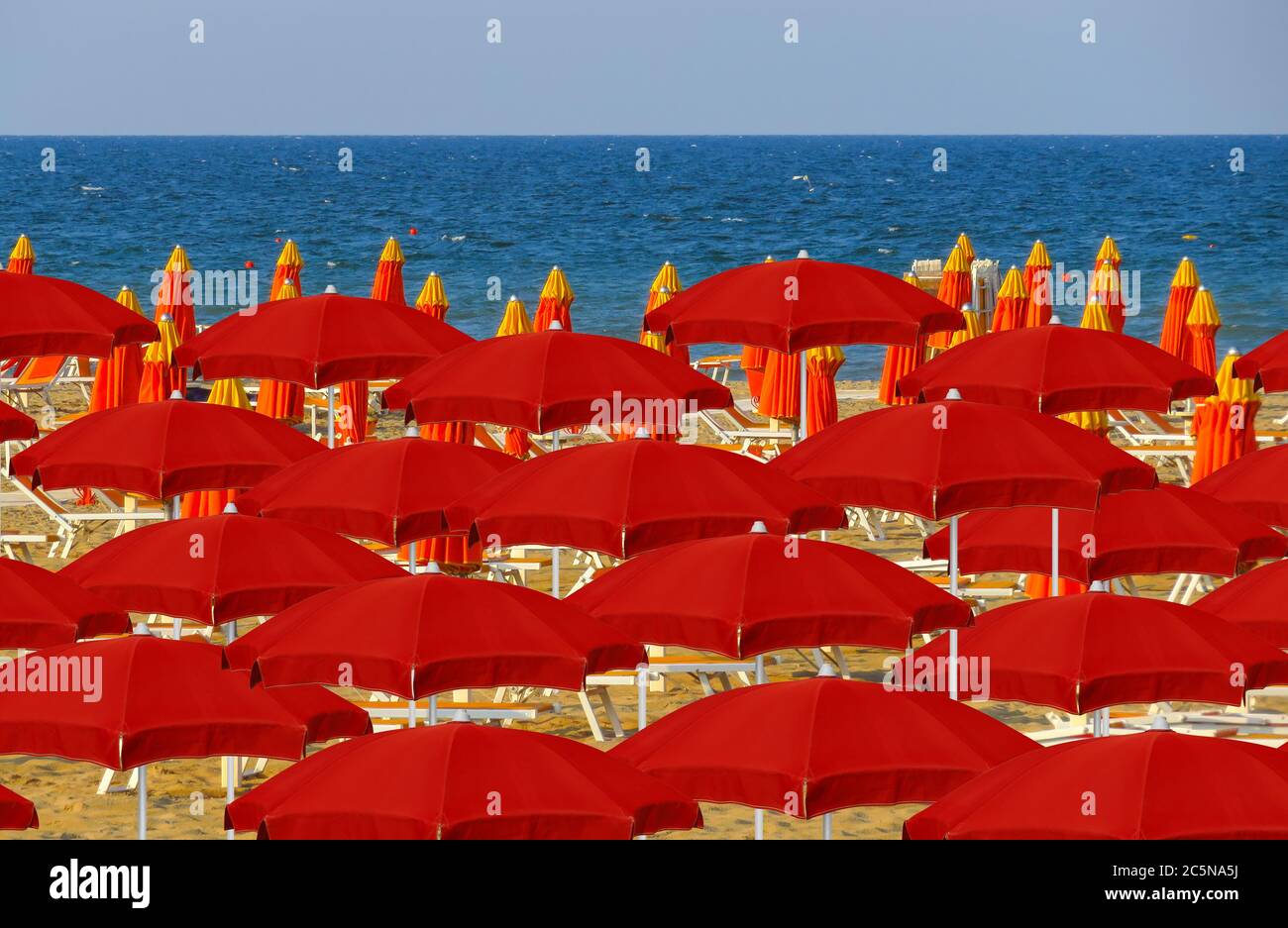 Red umbrellas on the beach of Rimini in Italy Stock Photo - Alamy
