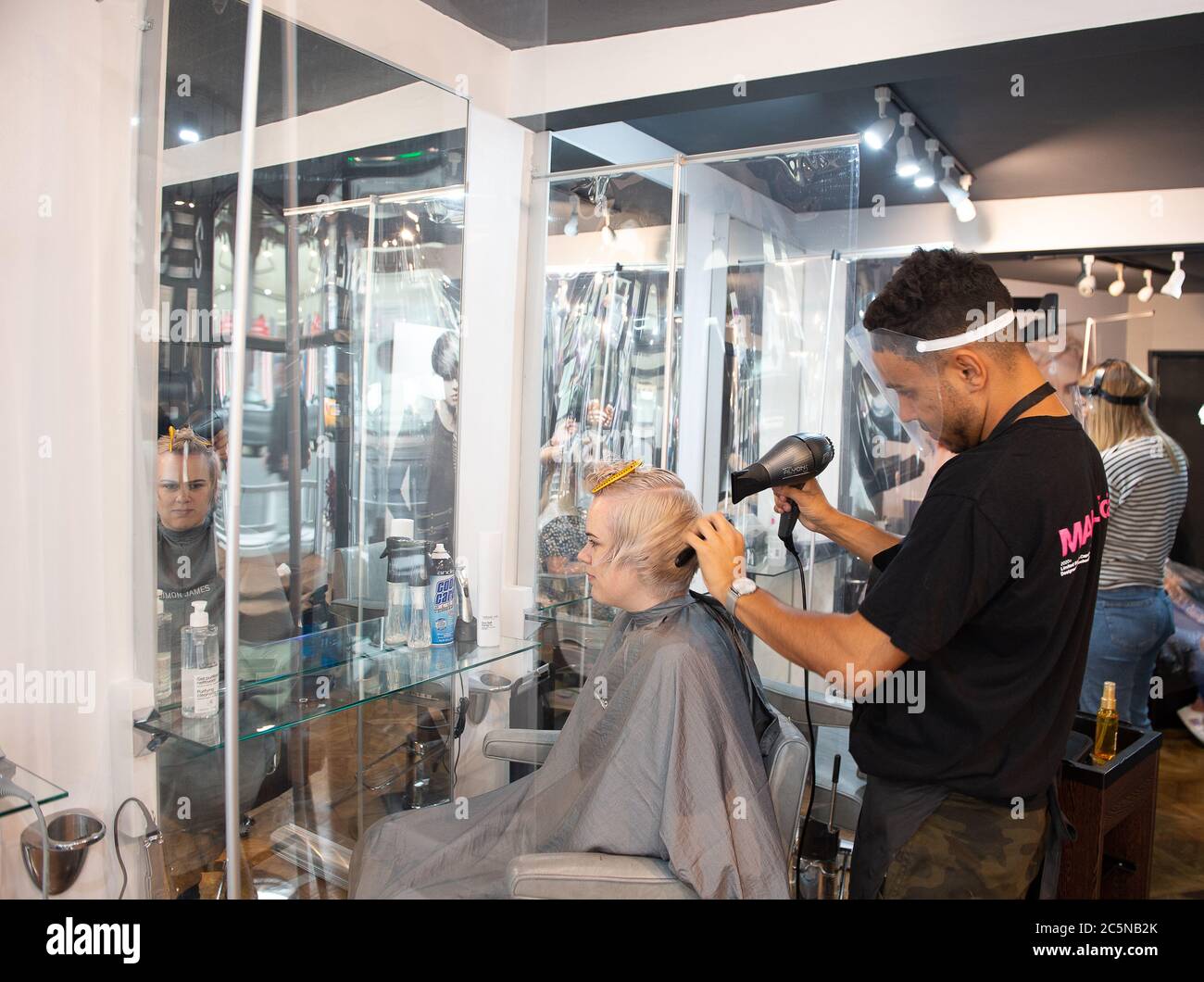 Eton, Windsor, Berkshire, UK. 4th July, 2020. Hairdressers at the Simon James salon in Eton High Street, Windsor, Berkshire were hectic this morning as hairdressers were allowed to reopen in England from today for the first time since the Coronavirus Covid-19 lockdown in March. Credit: Maureen McLean/Alamy Live News Stock Photo
