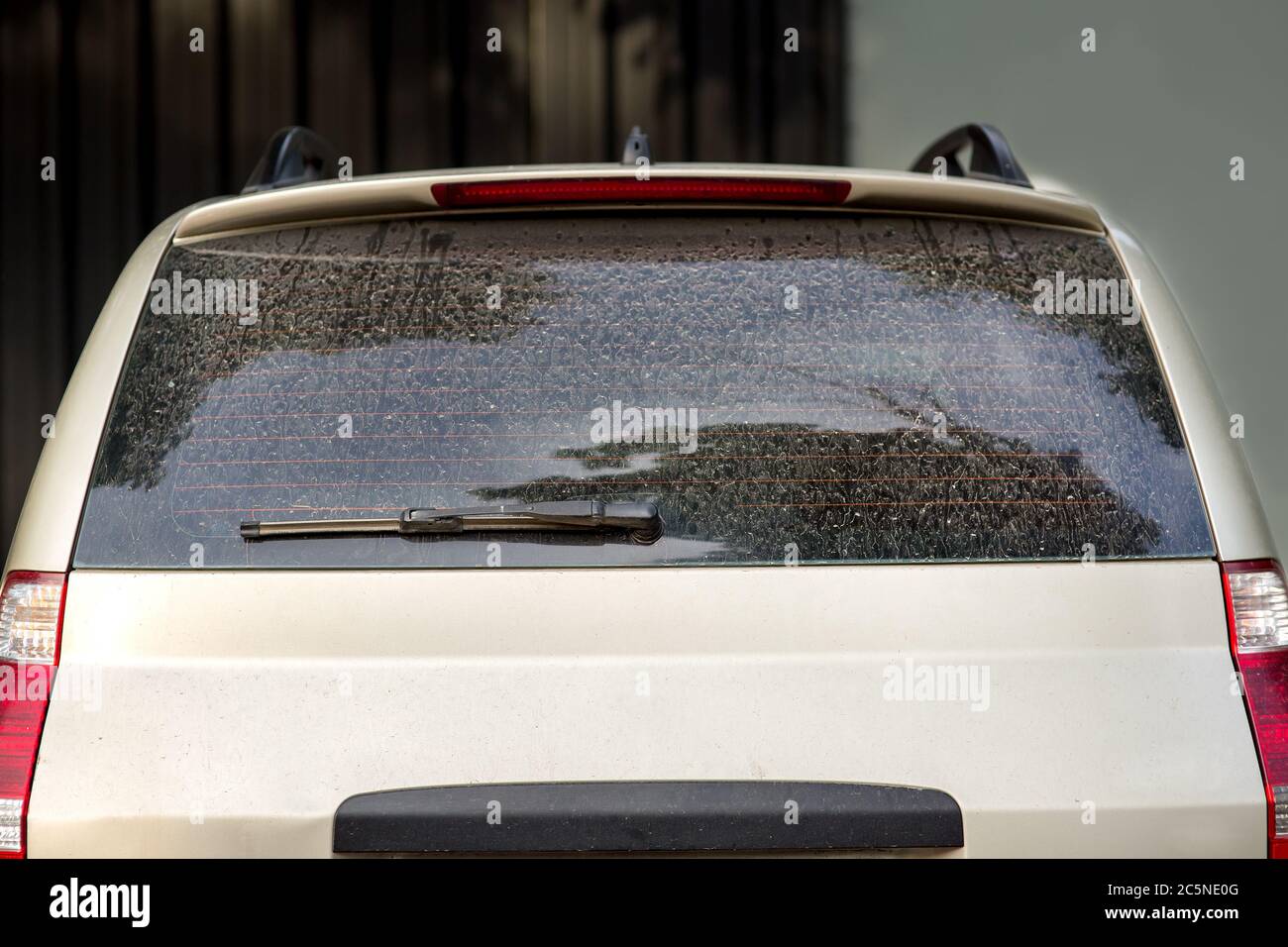rear view of a dirty car, hatchback with a dusty trunk lid and a faulty