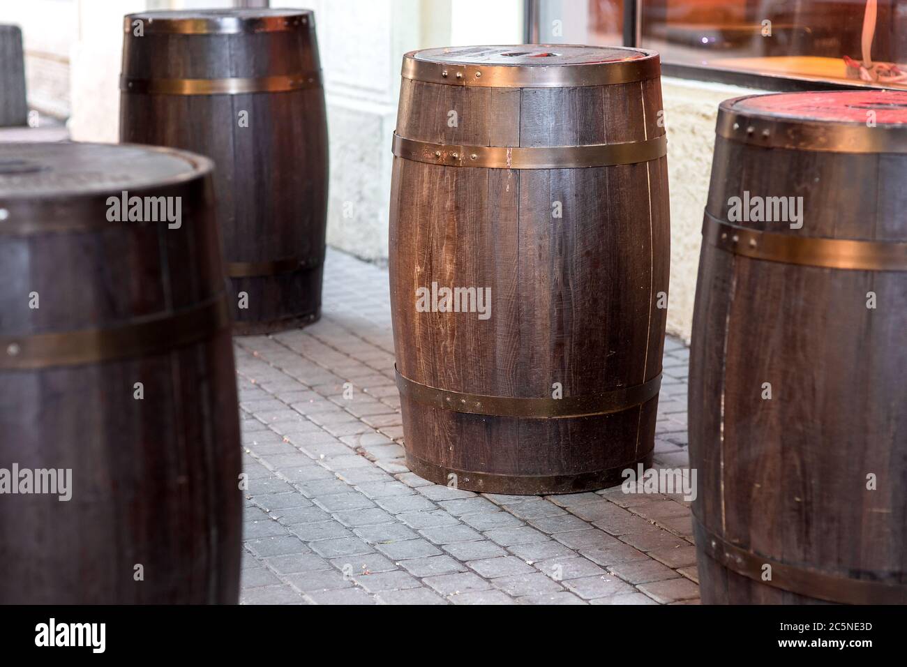 brown wooden rum barrel on the street on stone paving slabs, bar restaurant decorations close up nobody. Stock Photo