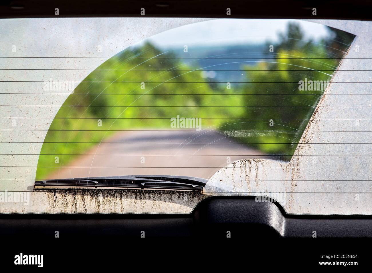 dirty car rear window in the dirt view from inside the car through