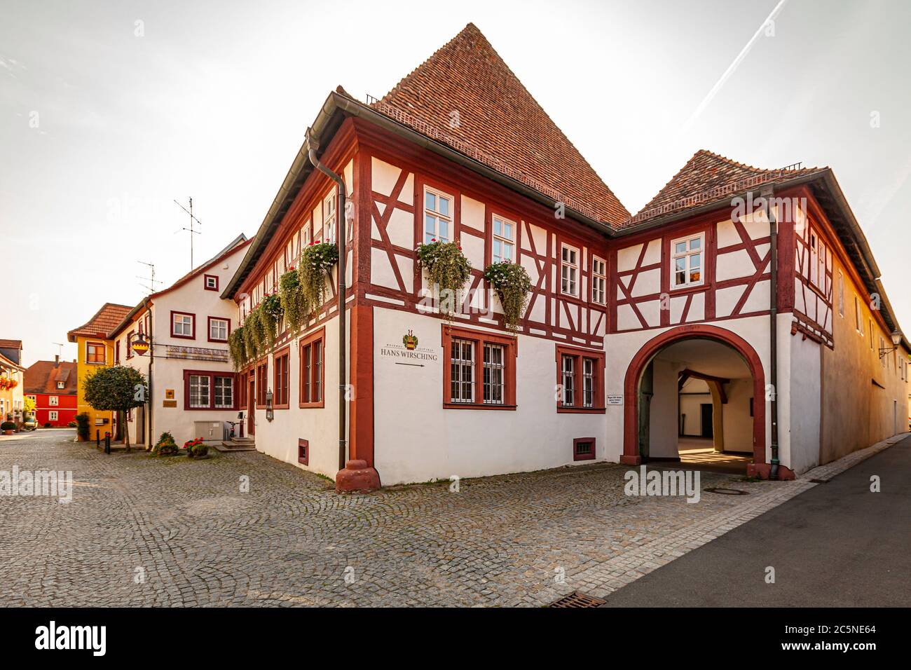 The half-timbered main house of the Hans Wirsching winery stands on a cobbled square in Iphofen, Bavaria, Germany; its gable dates back to the 16th century. The cellar beneath it is even older, reaching back to the 15th century. Between 1860 and 1950 the building housed a general store that helped support the Wirsching family. The winery, now run by the 14th generation, has been family-owned since 1630. Stock Photo