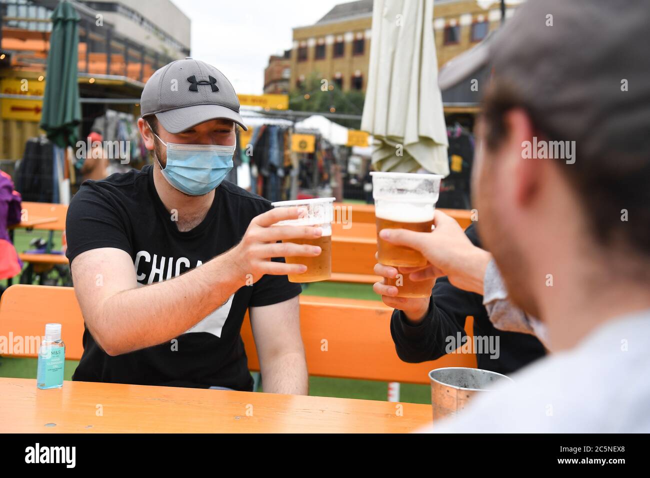 People enjoy drinks at the Vinegar Yard bar, London, as it reopens following the easing of coronavirus lockdown restrictions across England. Stock Photo