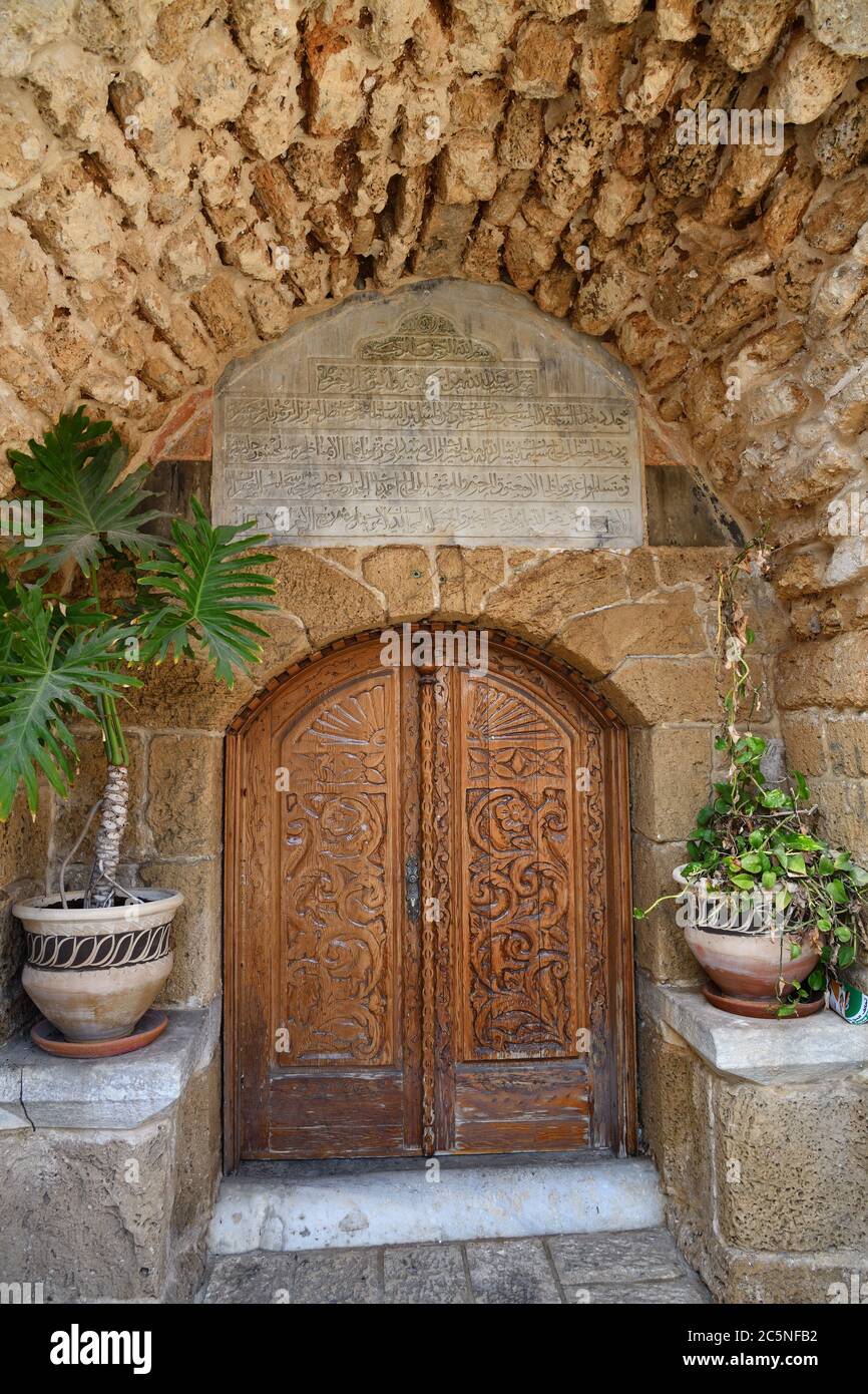 One ancient door on the Yefet street in Tel Aviv. Arabic text on the top of doorway means an ayats of the Koran. Israel Stock Photo
