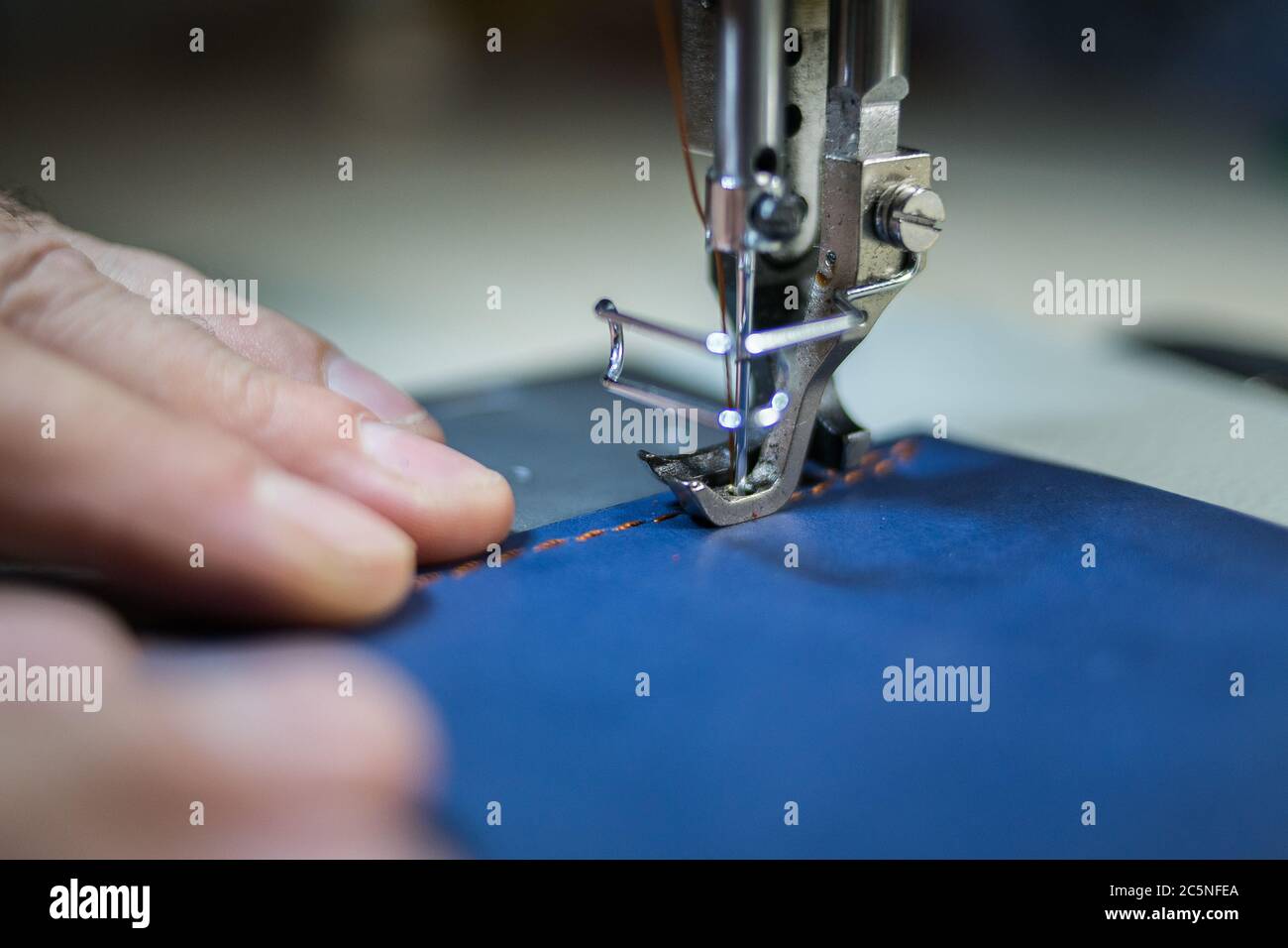 A man sews from leather on a sewing machine. Hands and sewing Stock