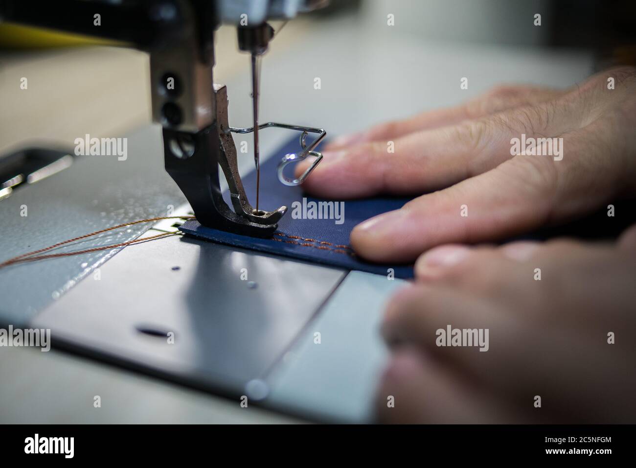 A man sews from leather on a sewing machine. Hands and sewing Stock