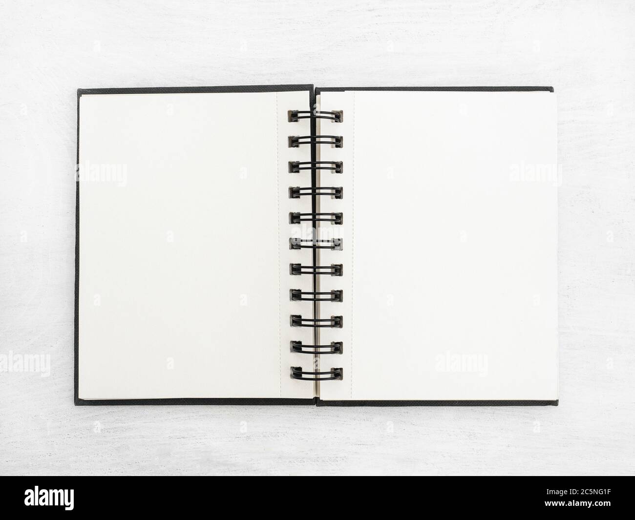 Blank notebook lying on a white table Stock Photo