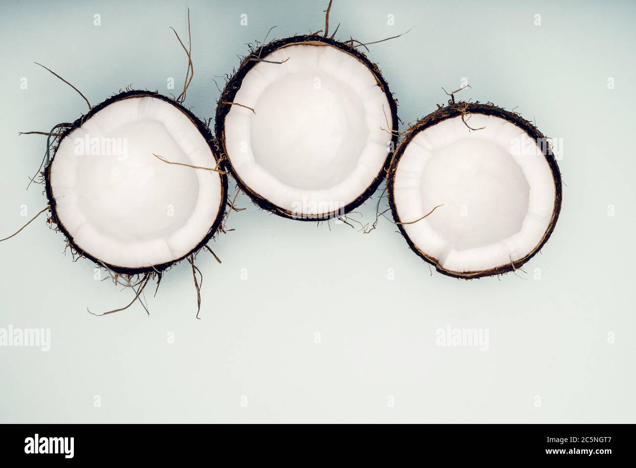 Parts of coconut on a colored background. Close up. Fresh ripe coconut