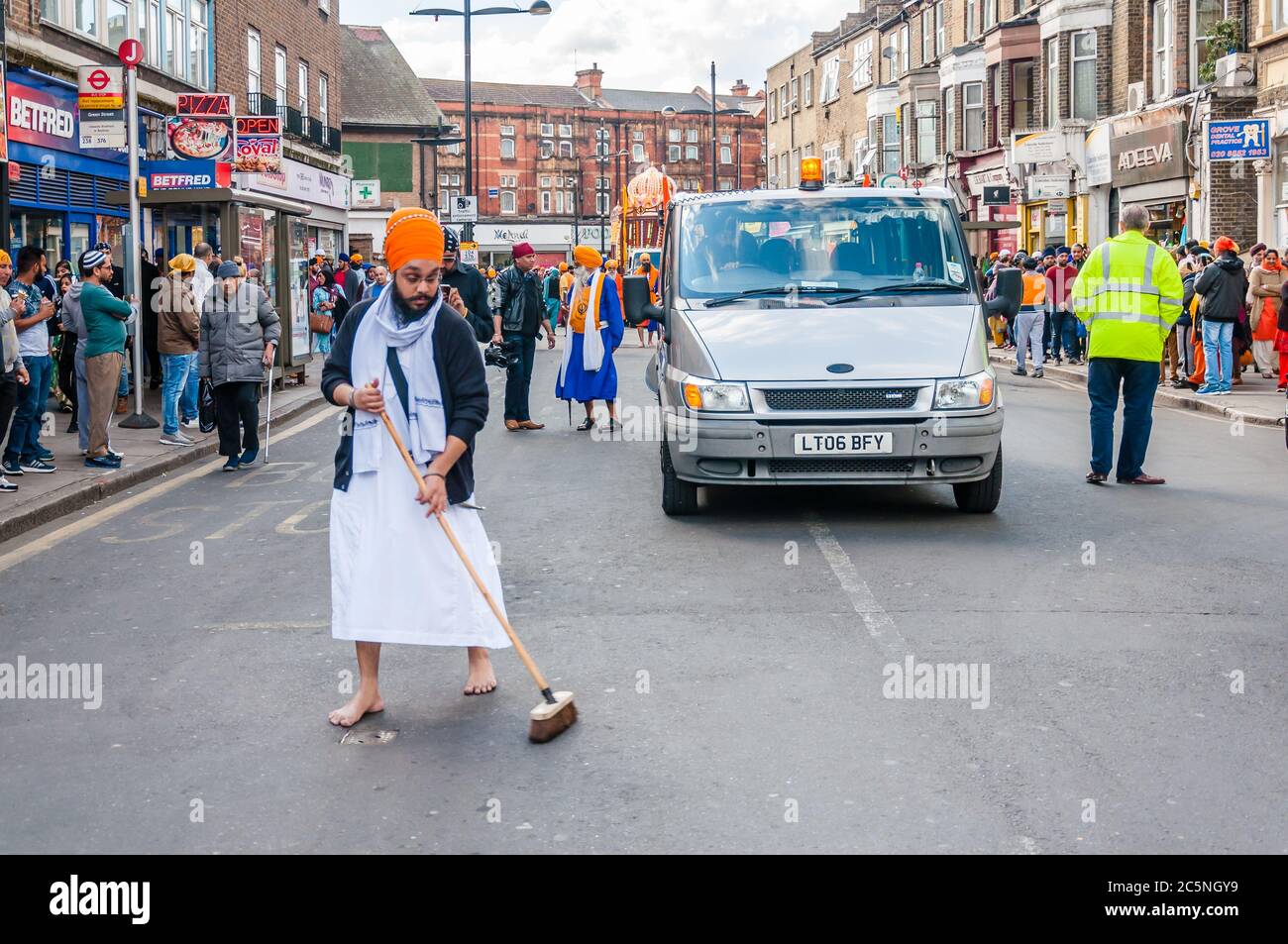 Devotees remove their shoes to sweep the road clean take part in the festival of Vaisakhi, celebrating the birth of Sikhs Stock Photo