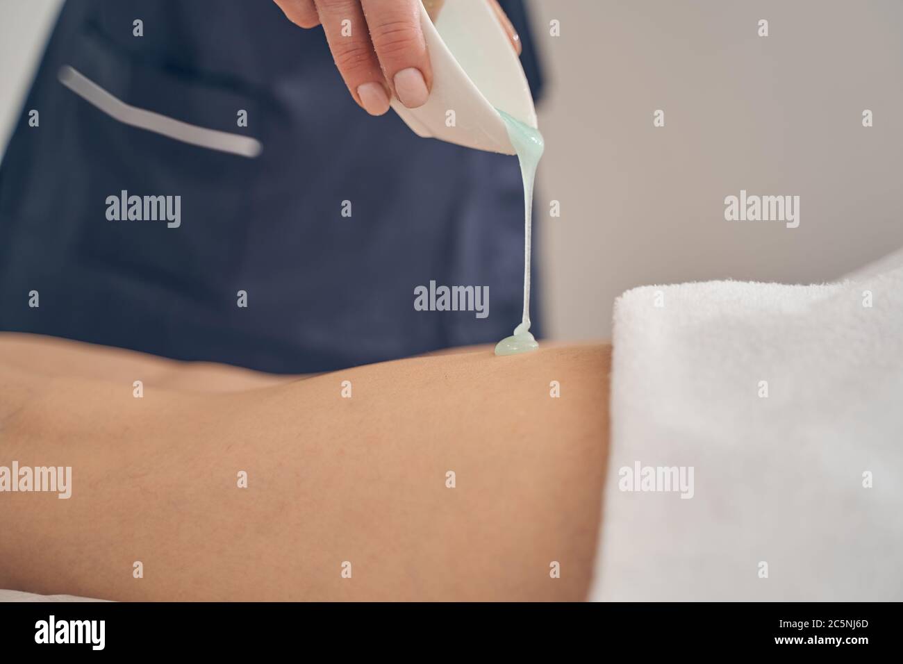 Beautician putting massage oil on the skin of the client Stock Photo