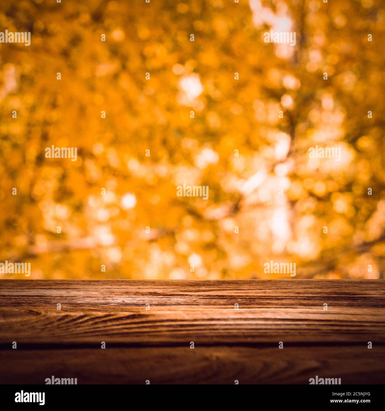 Empty wooden deck table with foliage bokeh background. Ready for ...