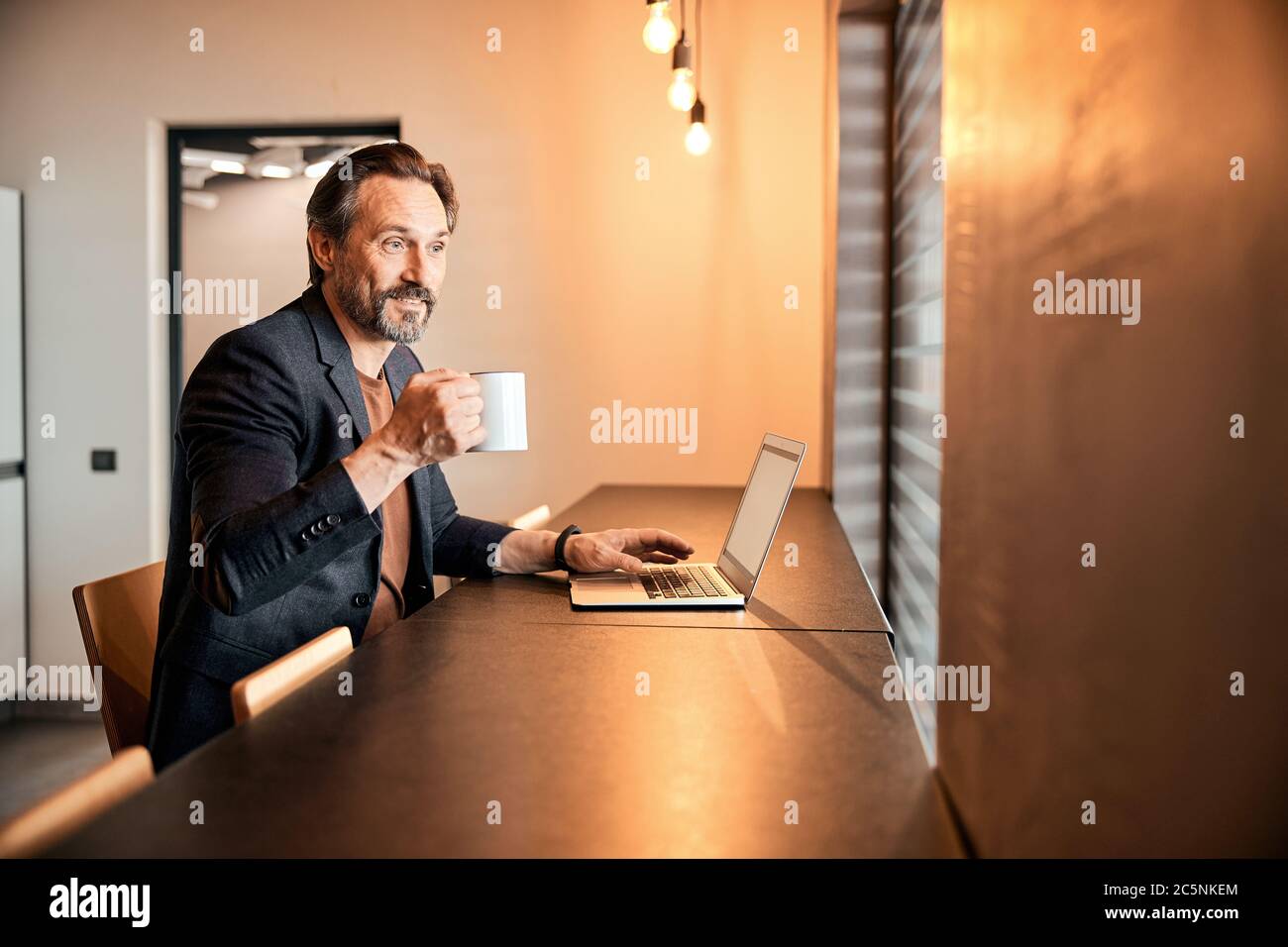 Businessman sitting at office desk having a coffee break Stock Photo