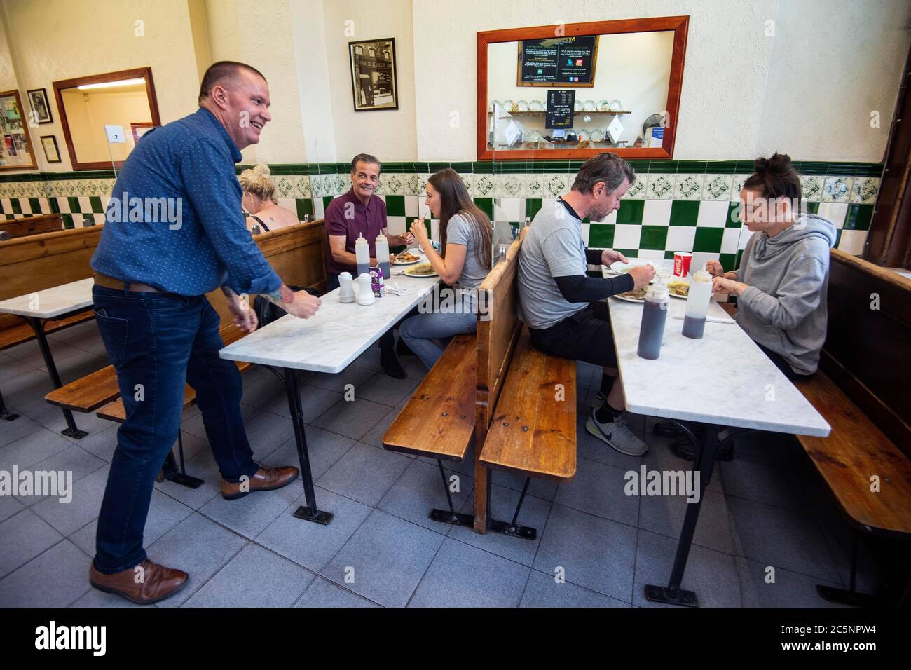 A staff member serves up pie and mash as M Manze, one of London's
