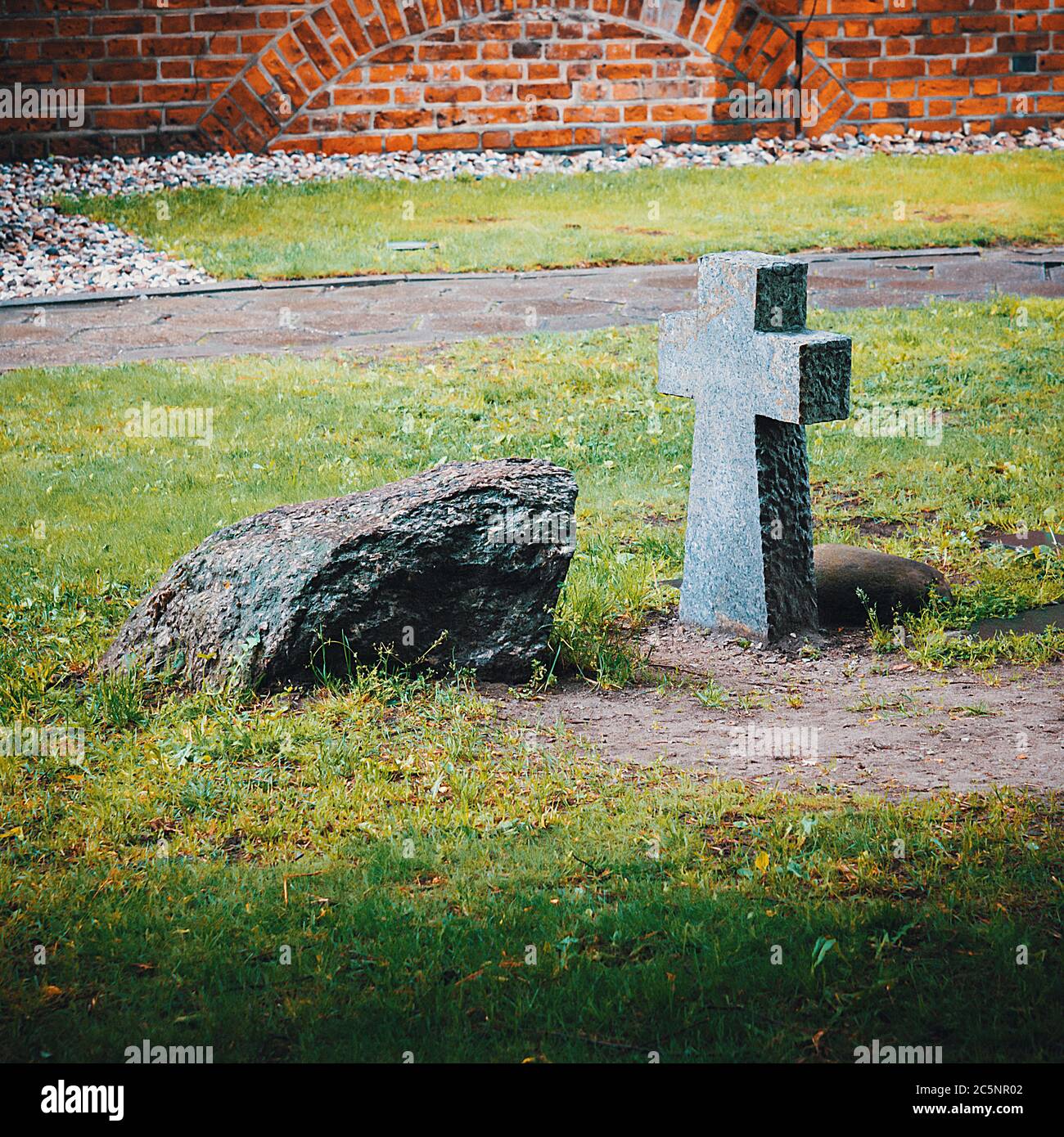 An Ancient Stone Funeral Cross And A Tombstone On The Burial Ground Near The Wall Of The Old Castle Stock Photo Alamy