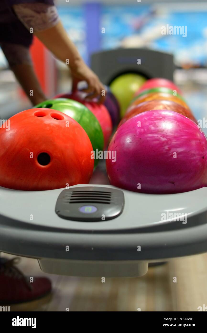 Bowling ball machine with person taking ball in the background Stock