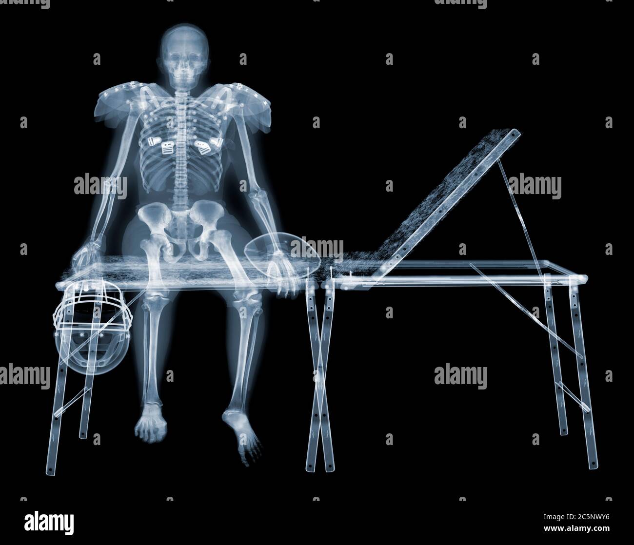 Skeleton of American footballer on sports couch, X-ray. Stock Photo