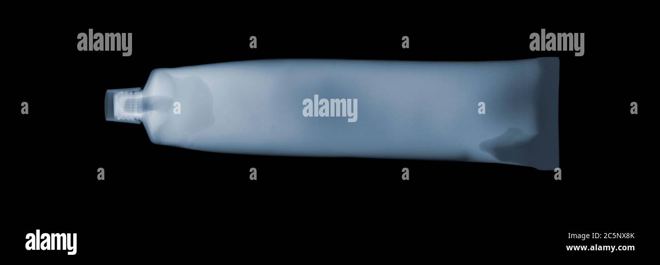 Toothpaste tube, coloured X-ray. Stock Photo