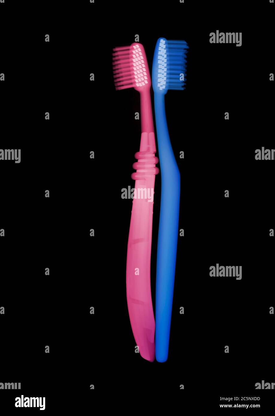 Pink and blue toothbrushes, coloured X-ray. Stock Photo