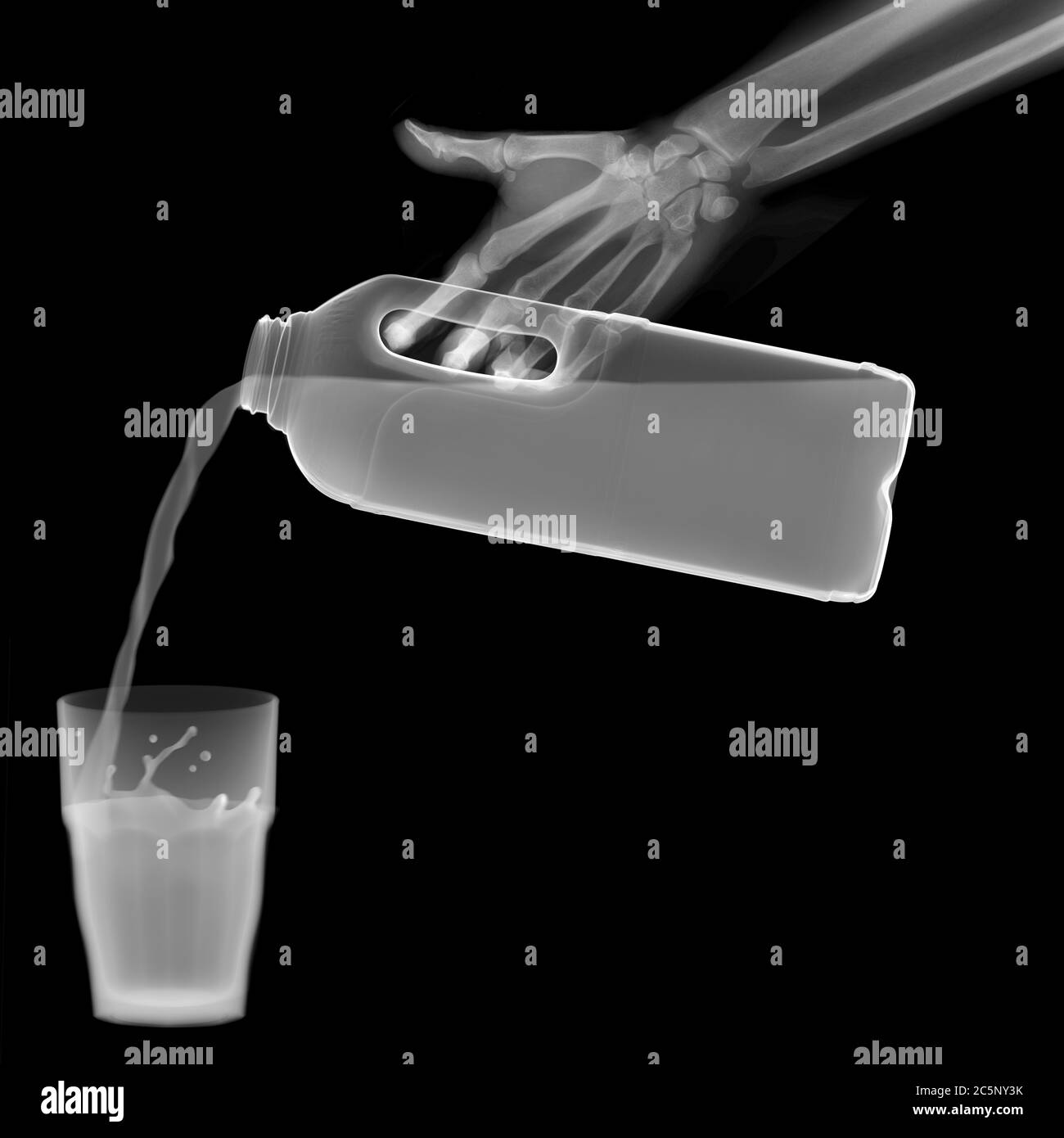 Milk pouring into a tumbler, X-ray. Stock Photo
